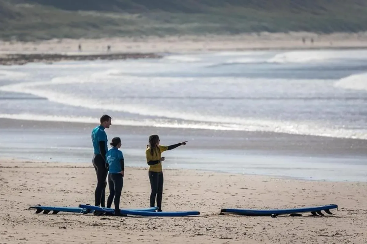 a group of people standing on a beach with surfboards