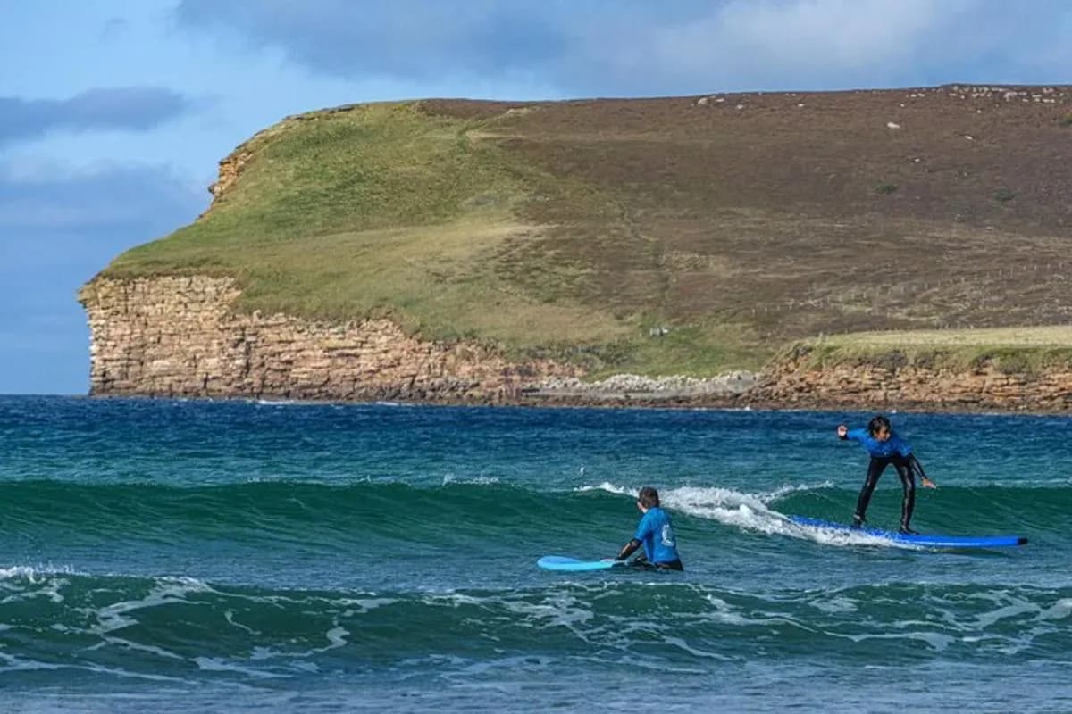 two people riding waves on surfboards in the ocean