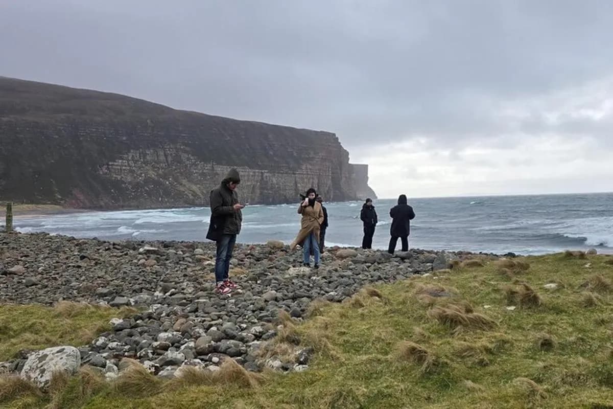 a group of people standing on a rocky beach