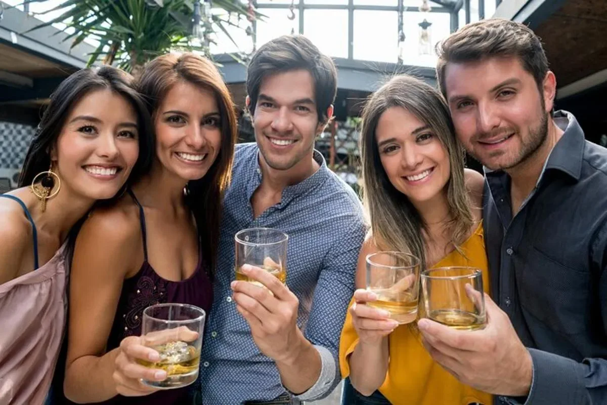 a group of people posing for a picture holding wine glasses