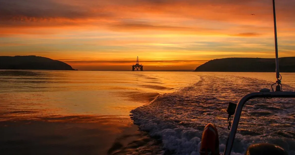 a boat in the water with a sunset in the background